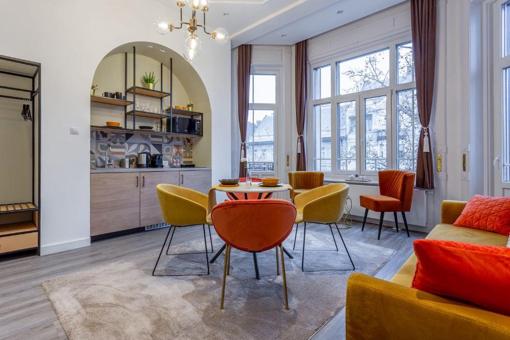 a living room with a table and chairs at Gellért Budapest Suites in Budapest