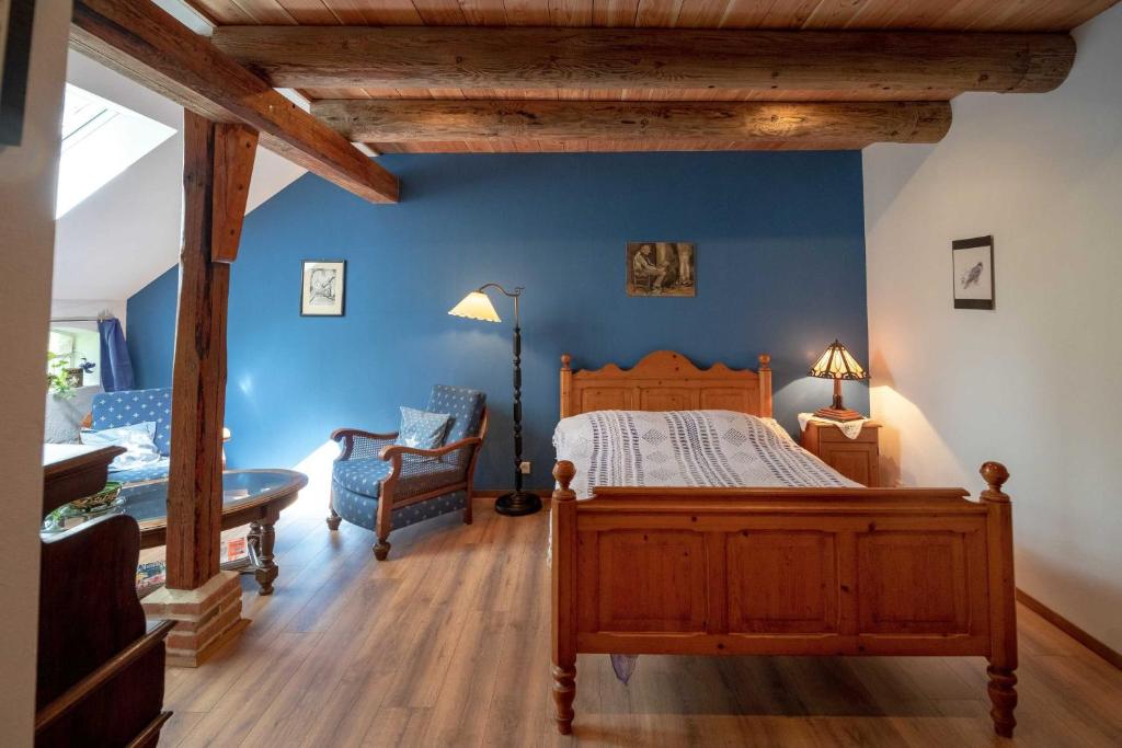 a bedroom with a wooden bed and a blue wall at Gästezimmer im Engelshof, 61224 in Moormerland