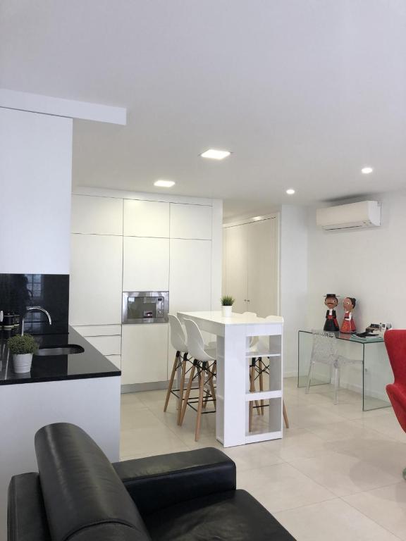 a living room with a table and a kitchen at VIANA é AMOR apartamento no centro histórico in Viana do Castelo