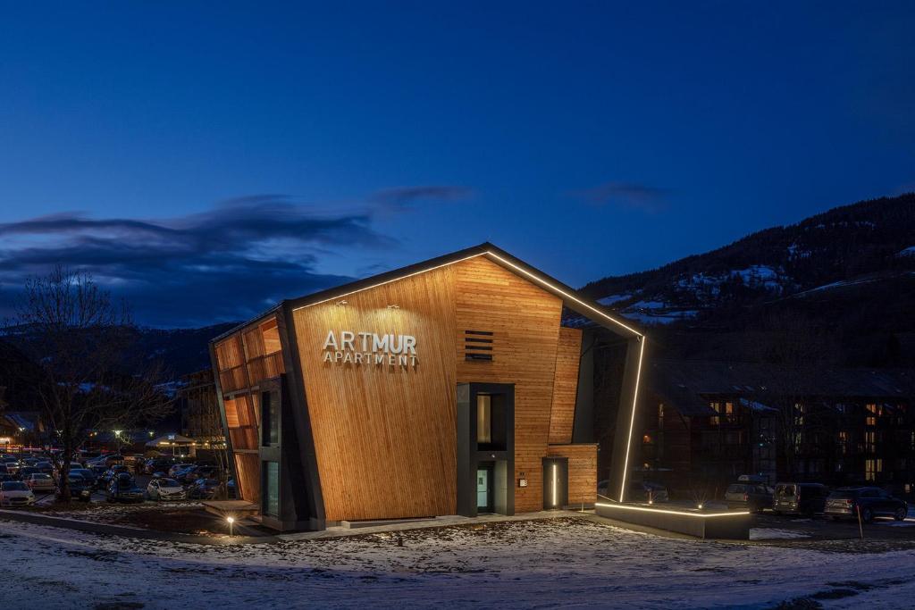 un bâtiment avec un panneau sur son côté dans l'établissement ARTMUR Apartment, à Sankt Georgen ob Murau