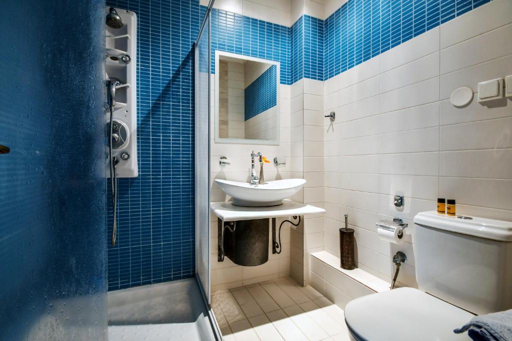 a bathroom with a sink and a toilet and blue tiles at Archontiko Liamas in Stavros