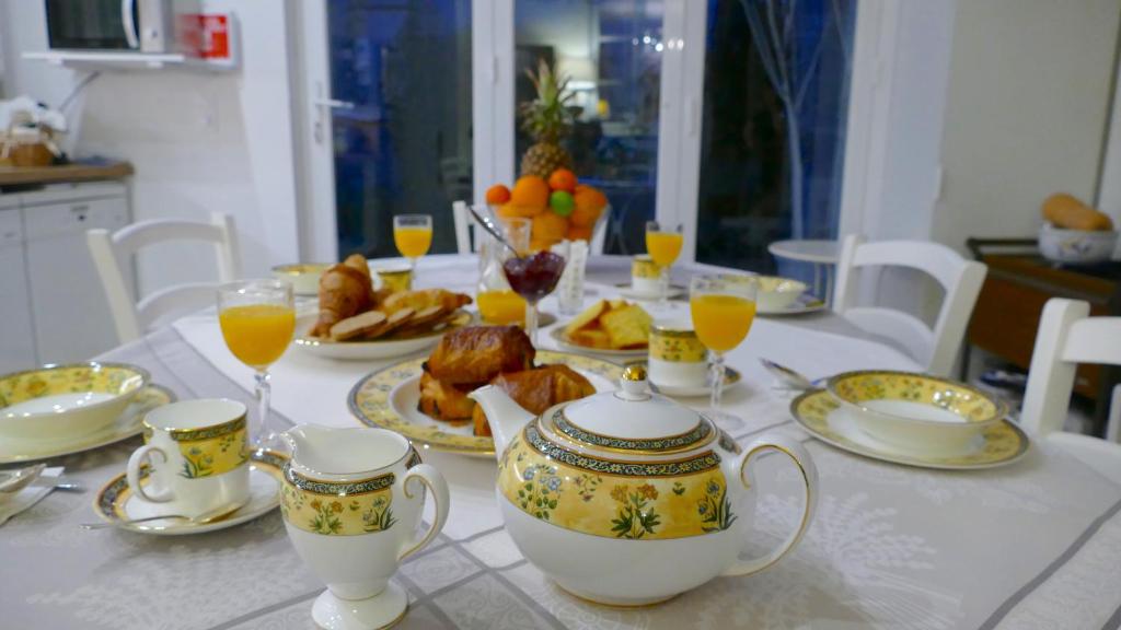 stół z filiżankami do herbaty i talerzami żywności w obiekcie Le 31 B&B Amboise Centre w mieście Amboise