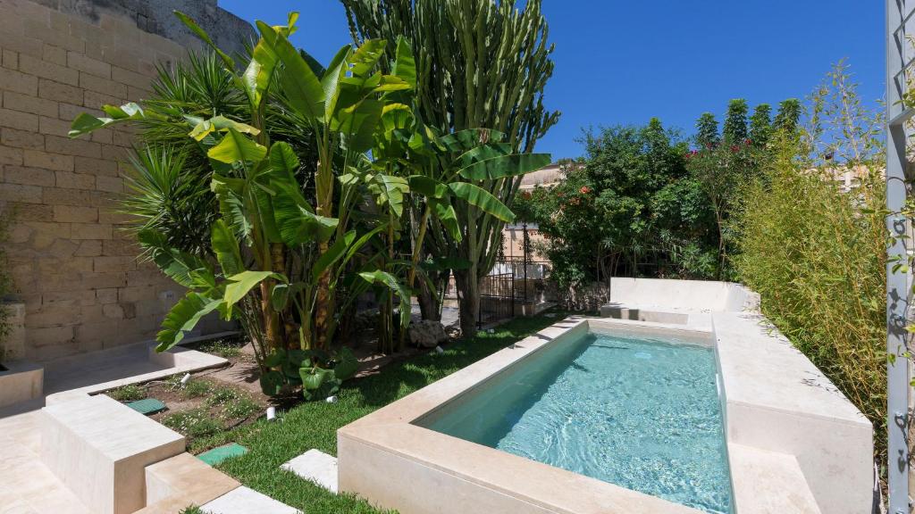 - une piscine dans une cour ornée de plantes dans l'établissement Palazzo Acquaviva - Il Giardino Sospeso, à Lecce