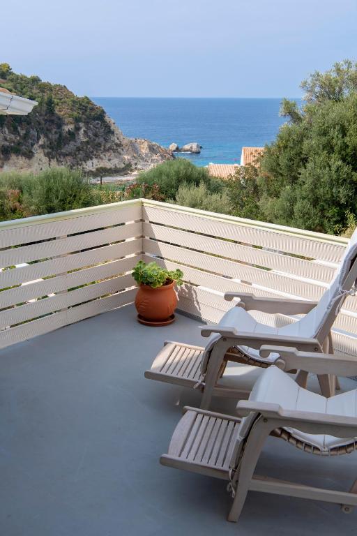 a balcony with two chairs and the ocean in the background at Villa Christianna Studios in Agios Nikitas