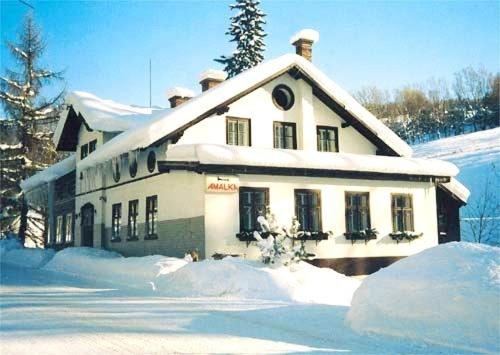 a building covered in snow with snow around it at Pension Amálka in Rokytnice nad Jizerou
