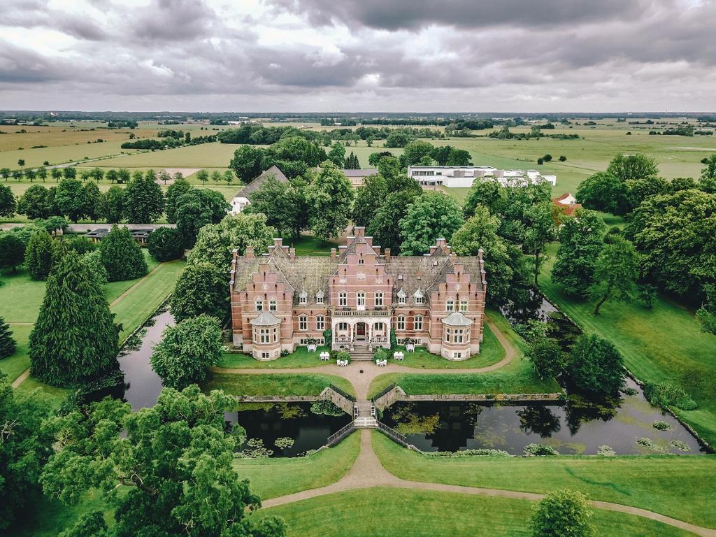 an aerial view of a large house with a pond at Fuglsang Herregaard Hotel in Nykøbing Falster