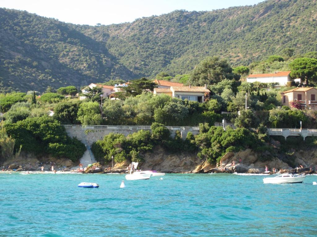un gruppo di barche in acqua vicino a una spiaggia di Hotel Belle Vue a Le Lavandou