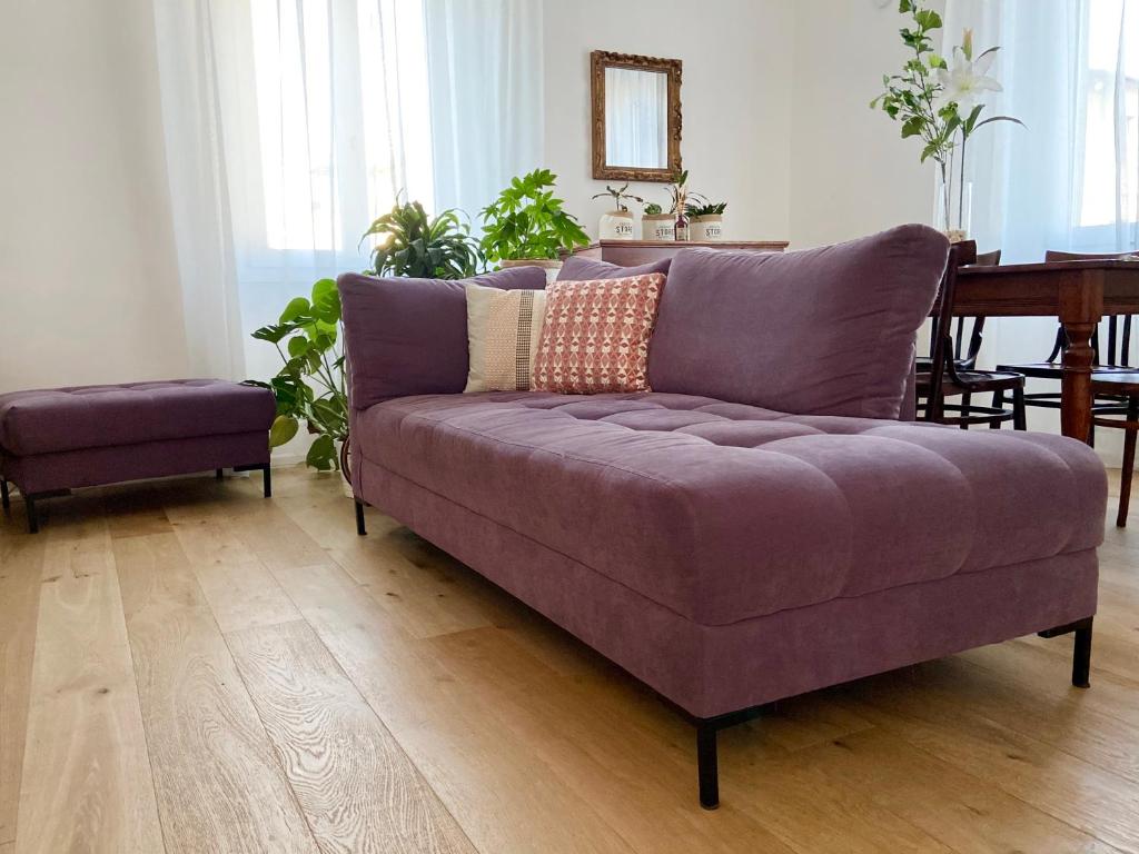 a purple couch in a living room with a table at Cantorial Charme in Florence