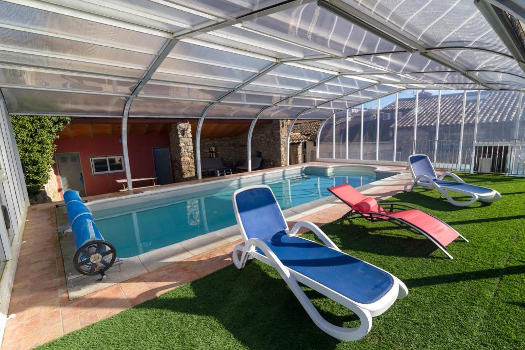 a swimming pool with lounge chairs and a swimming poolvisor at Casa el Francés in Graus