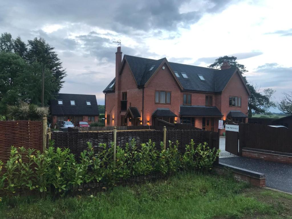 a house with a fence in front of a yard at The spinney home stay in Leamington Spa