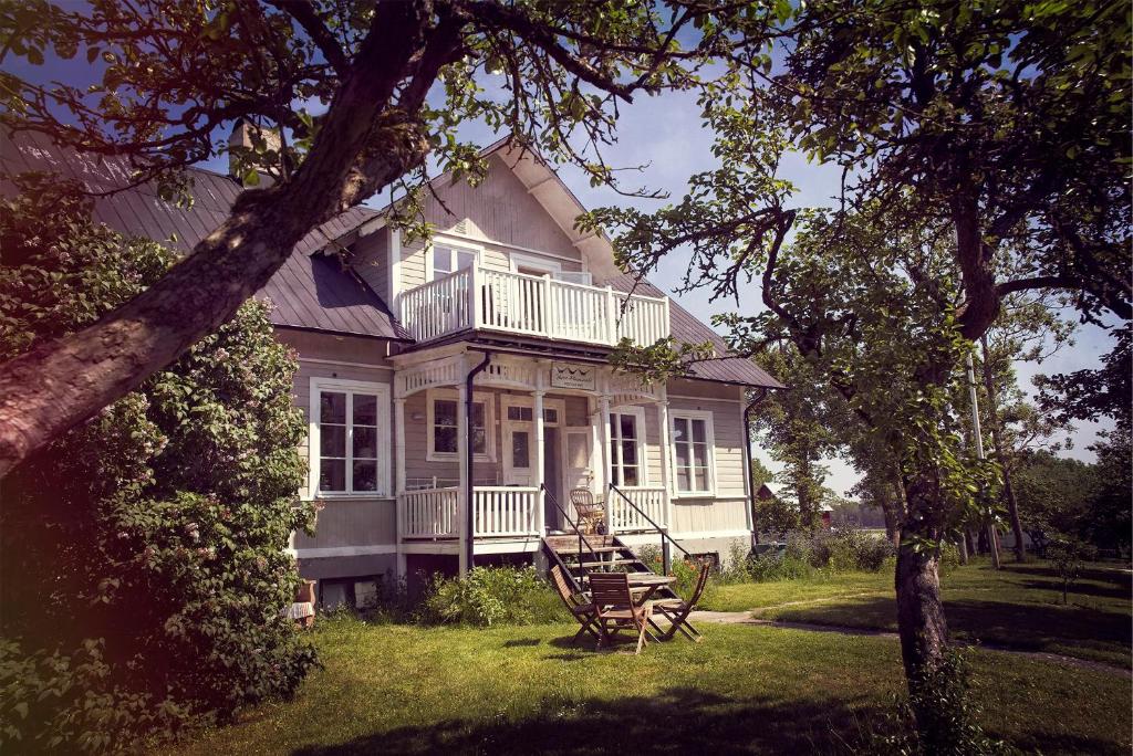 a large white house with a porch and a deck at Three Pheasants Boutique Bed and Breakfast in Ekeby