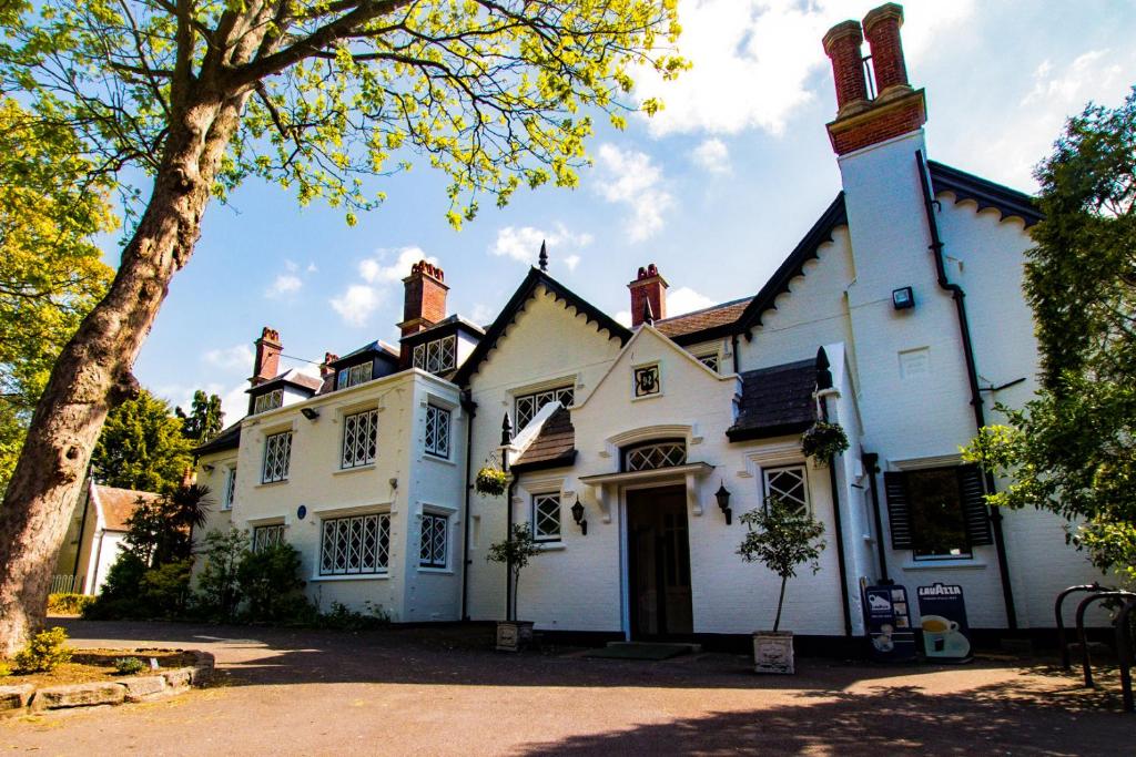 uma casa branca com uma árvore em frente em The Alverbank Hotel em Gosport