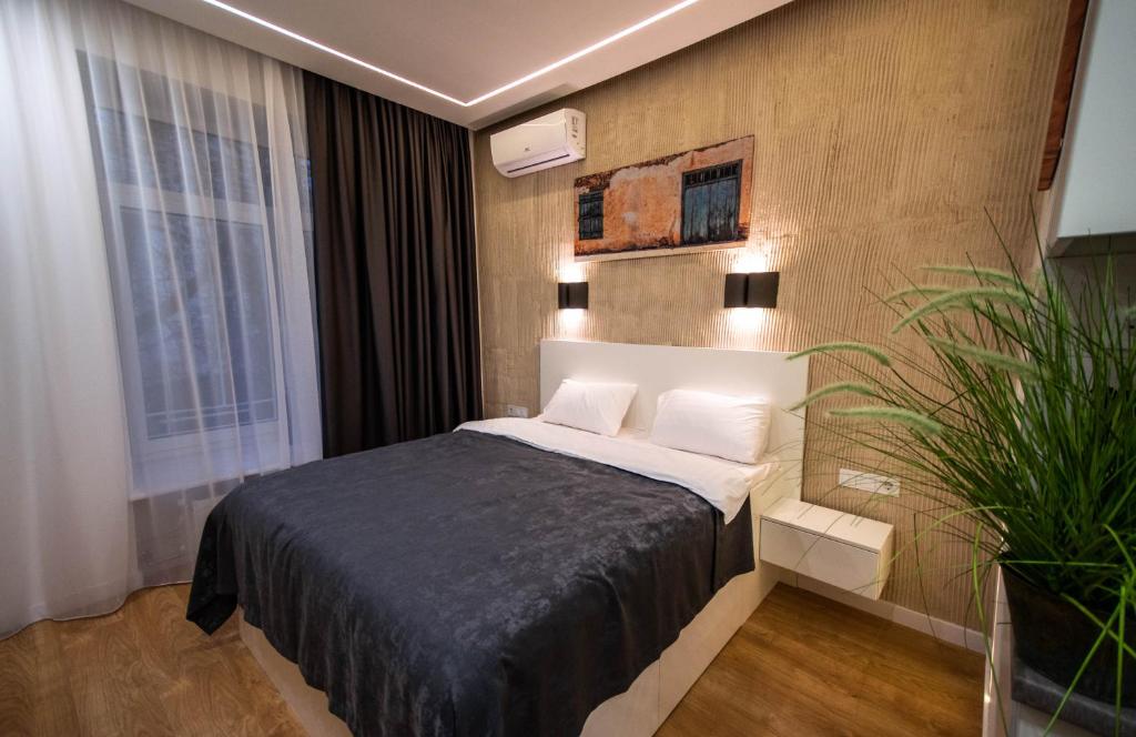 a bedroom with a bed and a plant in it at Smart Apartment in Kyiv Center in Kyiv