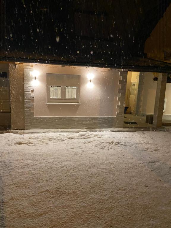 un bâtiment avec une fenêtre dans la neige dans l'établissement Lake apartment, à Blidinje
