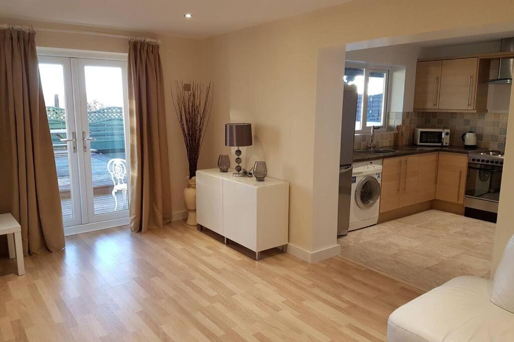 a living room with a kitchen and a living room with at Sister's Apartment in Llanelli