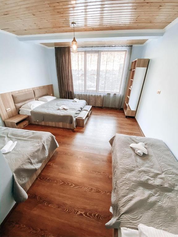 a room with two beds and a couch at Hotel panorama svaneti in Mestia