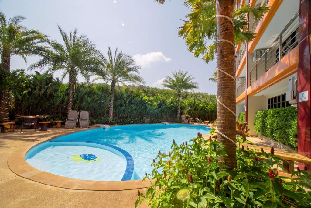 een zwembad met palmbomen en een gebouw bij Квартира вид на бассейн NBC S402 by IBG Property in Nai Harn Beach