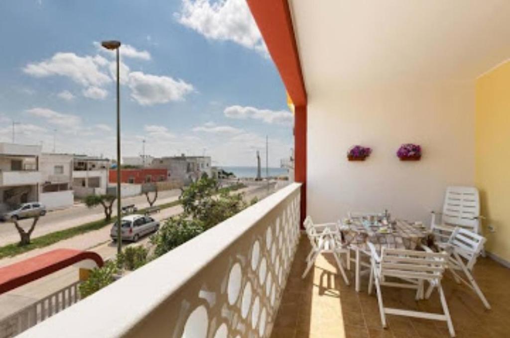 a balcony with a table and a view of a street at Appartamento Rosamarina in Torre Lapillo