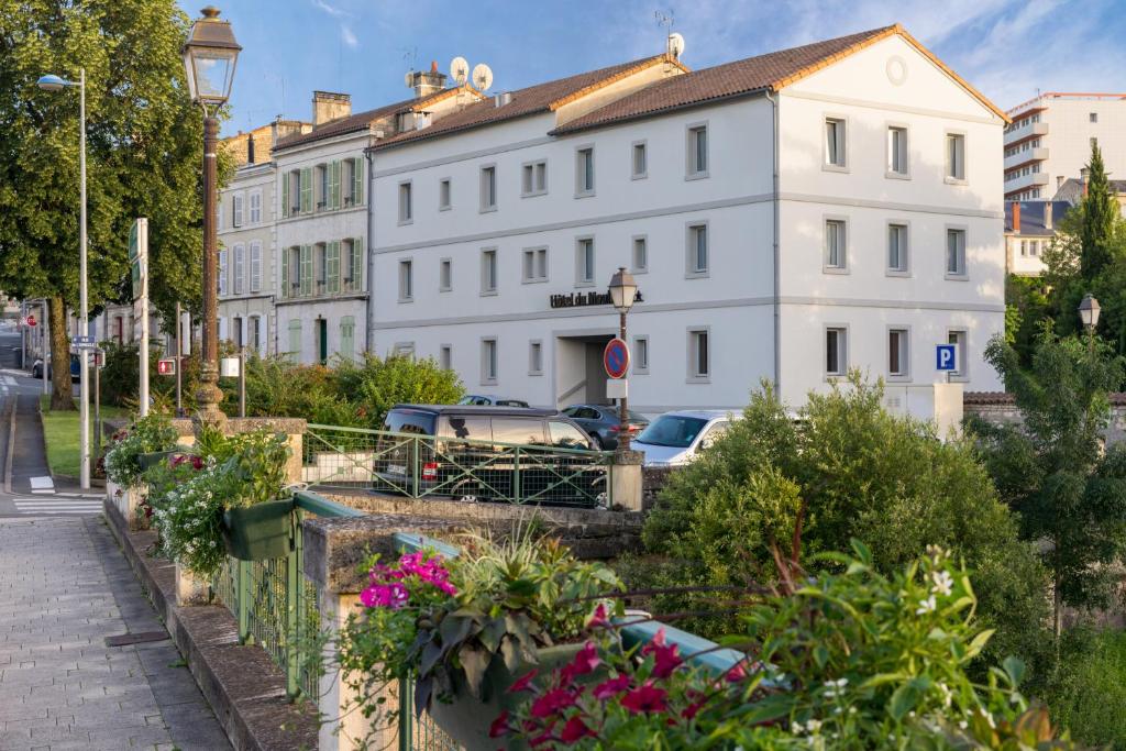 een straat met een wit gebouw en wat bloemen bij Hôtel du Moulin in Niort