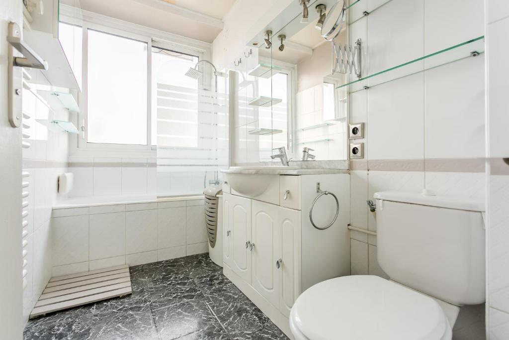 uma casa de banho com um WC, um lavatório e uma banheira em La Muette Terrasse vue Tour Eiffel em Paris