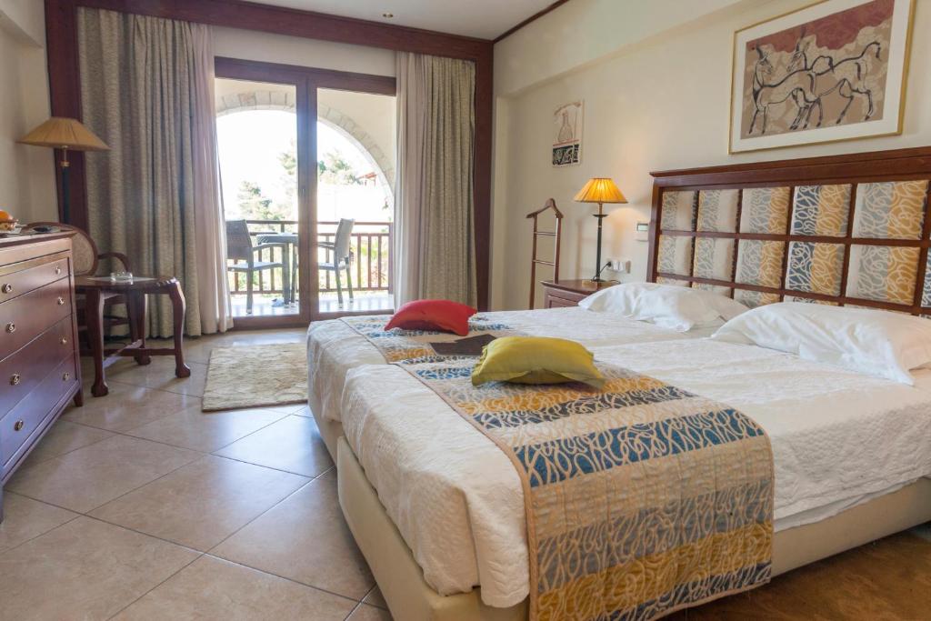 Rúm í herbergi á Aegean Melathron Thalasso Spa Hotel