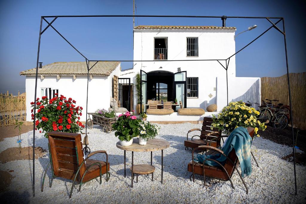 Almácera的住宿－Partida de la Mar，一座带椅子和鲜花桌子的房子