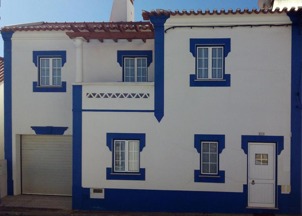 a blue and white house with a door and windows at CASA DA BARRA AZUL by Stay in Alentejo in Vila Nova de Milfontes