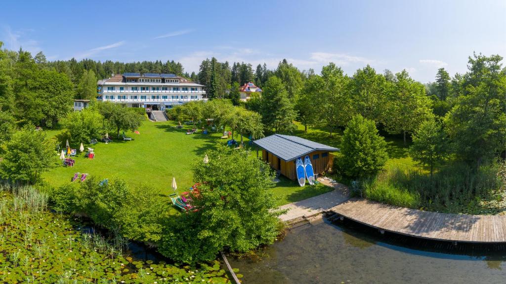 an aerial view of a park with a building and a river at Strandhotel Klopeinersee in Sankt Kanzian