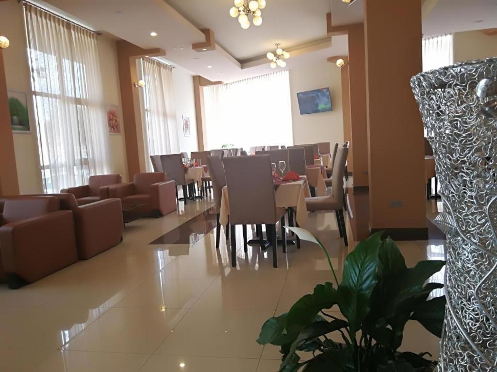 a dining room with tables and chairs in a building at Ye Afoli International Hotel in Addis Ababa