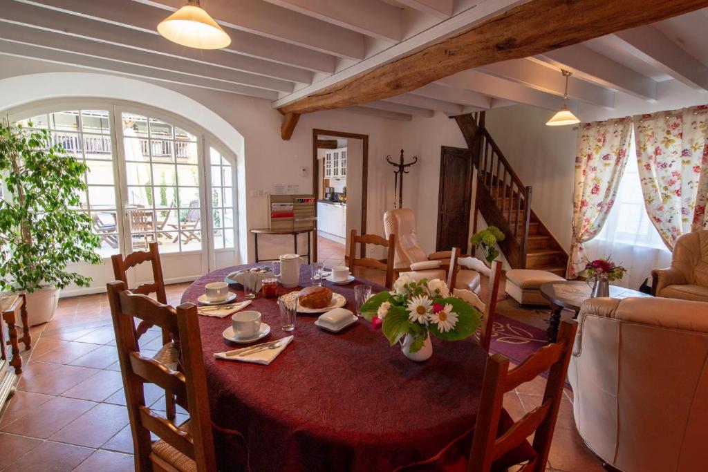 a living room with a dining table and a living room at Au Temps Retrouvé in Courcelles