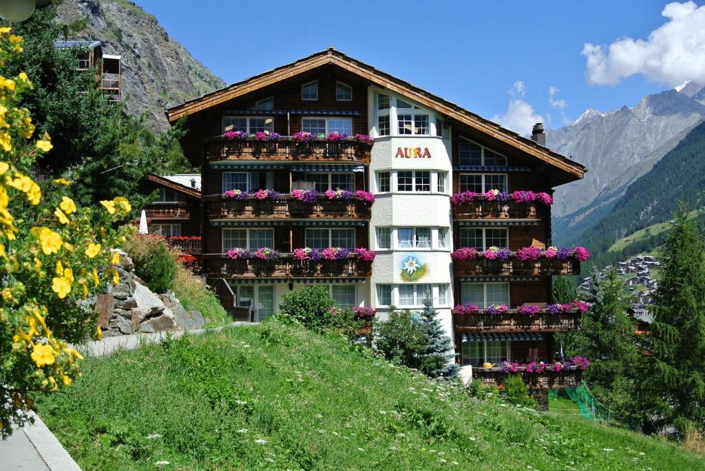 un edificio con flores al lado de una colina en Apartment Aura, en Zermatt