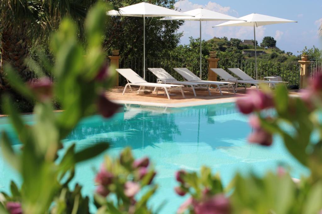 a swimming pool with lounge chairs and umbrellas at Il Mandorlo in Amantea