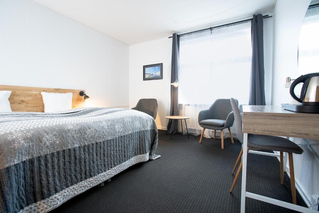 um quarto de hotel com uma cama, uma secretária e uma janela em Billum Kro em Billum