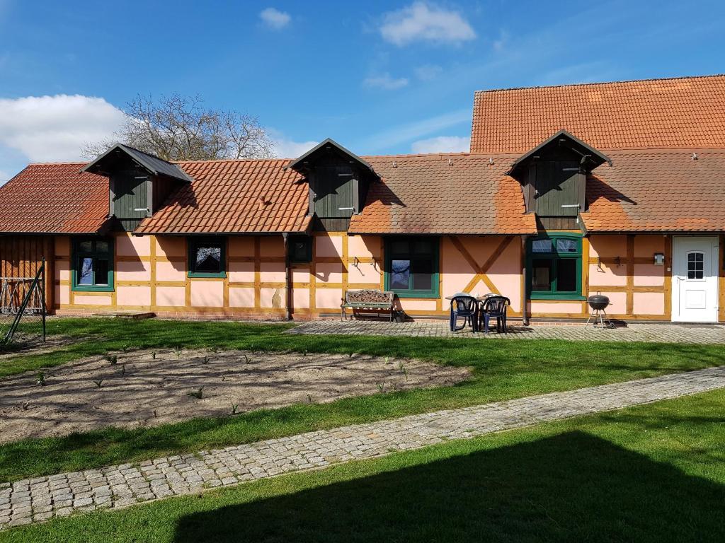 a building with a red roof and a bench at Ferienhaus Sooß in Heiligengrabe