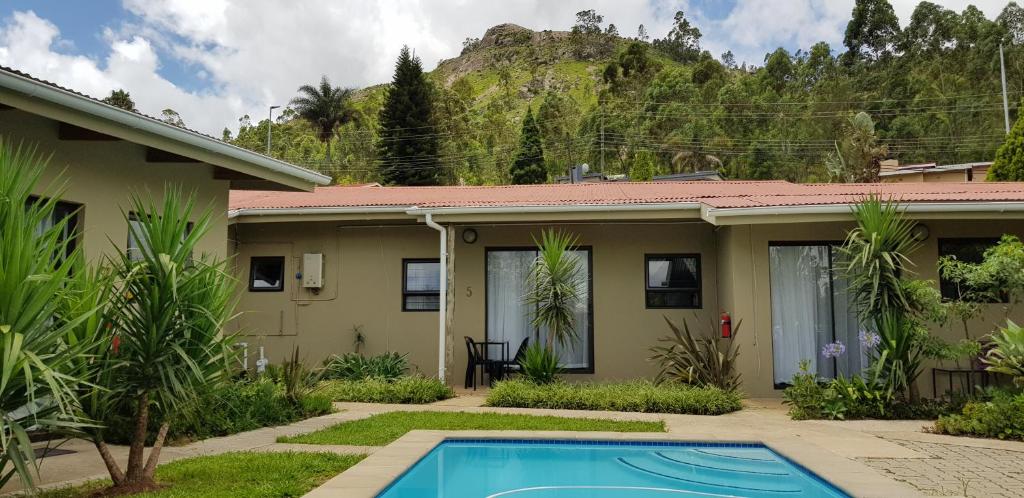 a house with a swimming pool in front of it at Veki's Town Lodge in Mbabane