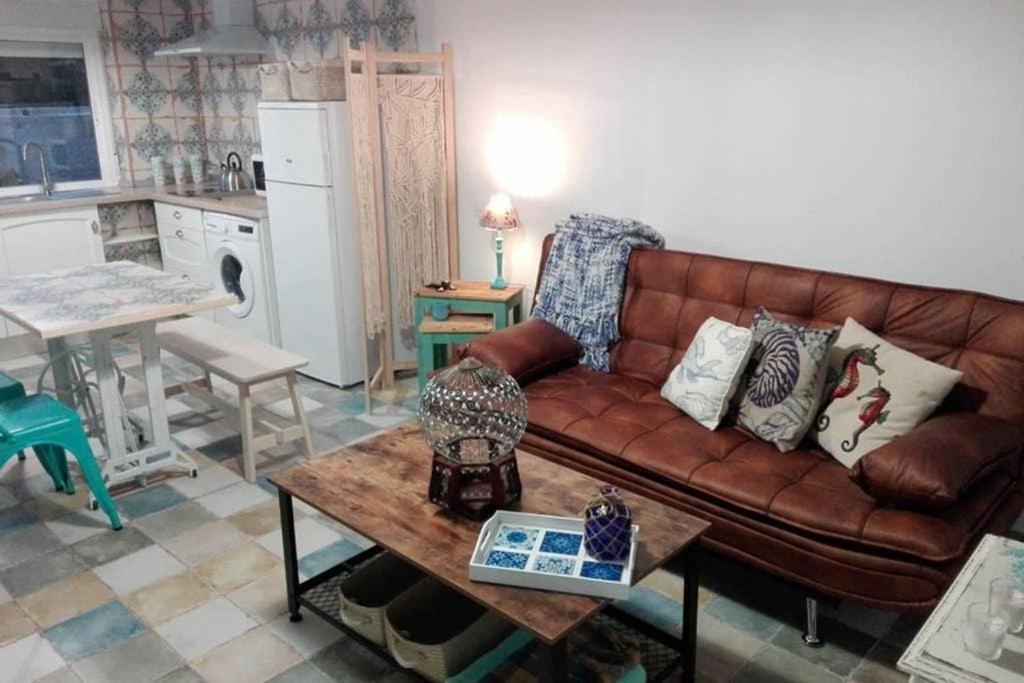 ein Wohnzimmer mit einem braunen Sofa und einem Tisch in der Unterkunft Arabias Loft Caños de Meca in Los Caños de Meca