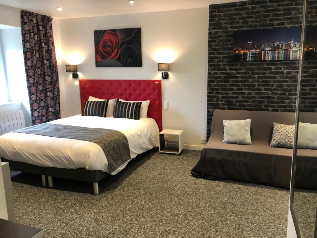 a bedroom with a red headboard and a bed at L' Annexe Beverl'inn in Flers