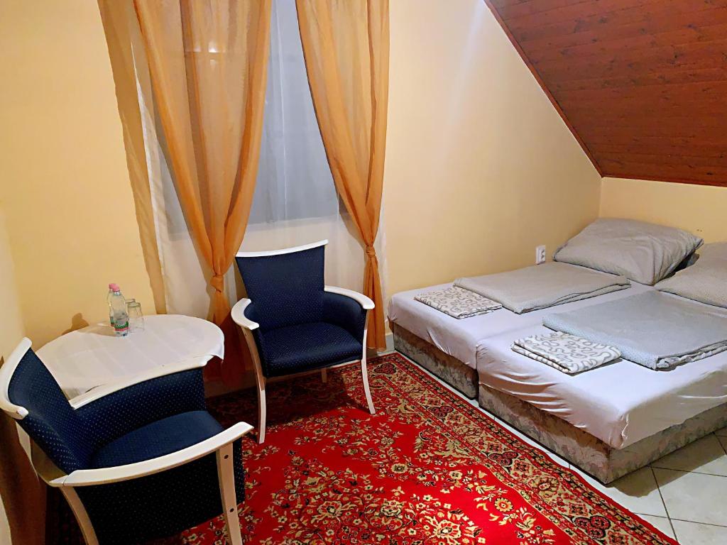 una camera con letto, sedia e tavolo di Koloska apartmanház a Balatonfüred