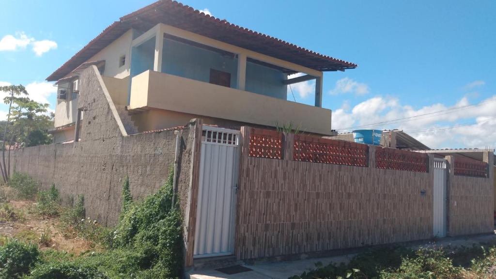 una casa con una valla delante de ella en Casa Morada da Praia 2, en Peroba