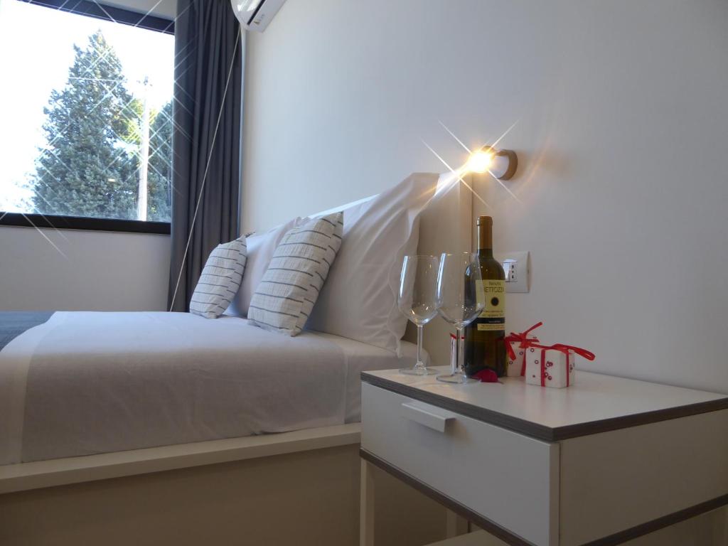 een slaapkamer met een bed en een tafel met een fles wijn bij Agriturismo Tenuta Bettozza in Sasso Marconi