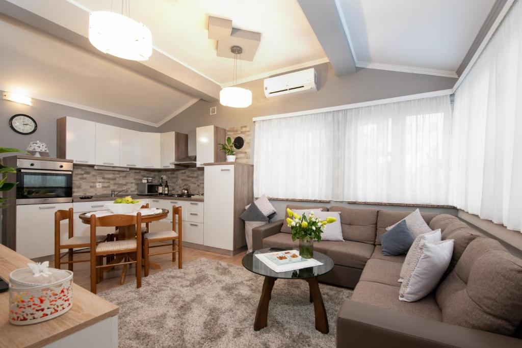 ein Wohnzimmer mit einem Sofa und einem Tisch in der Unterkunft Apartman Slavica in Rijeka