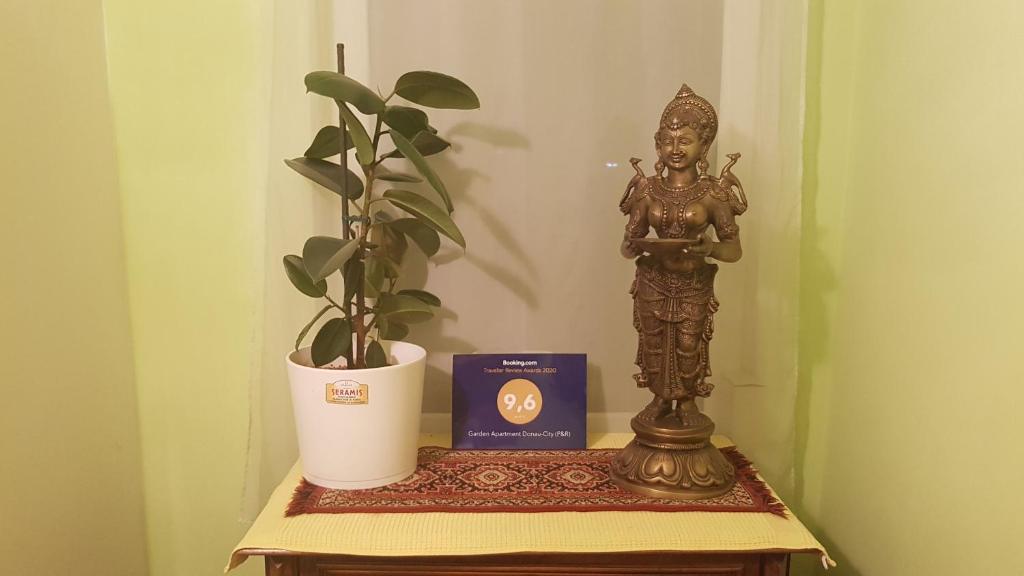 a statue and a box on a table with a plant at Garden Apartment Donau-City (P&R) in Vienna