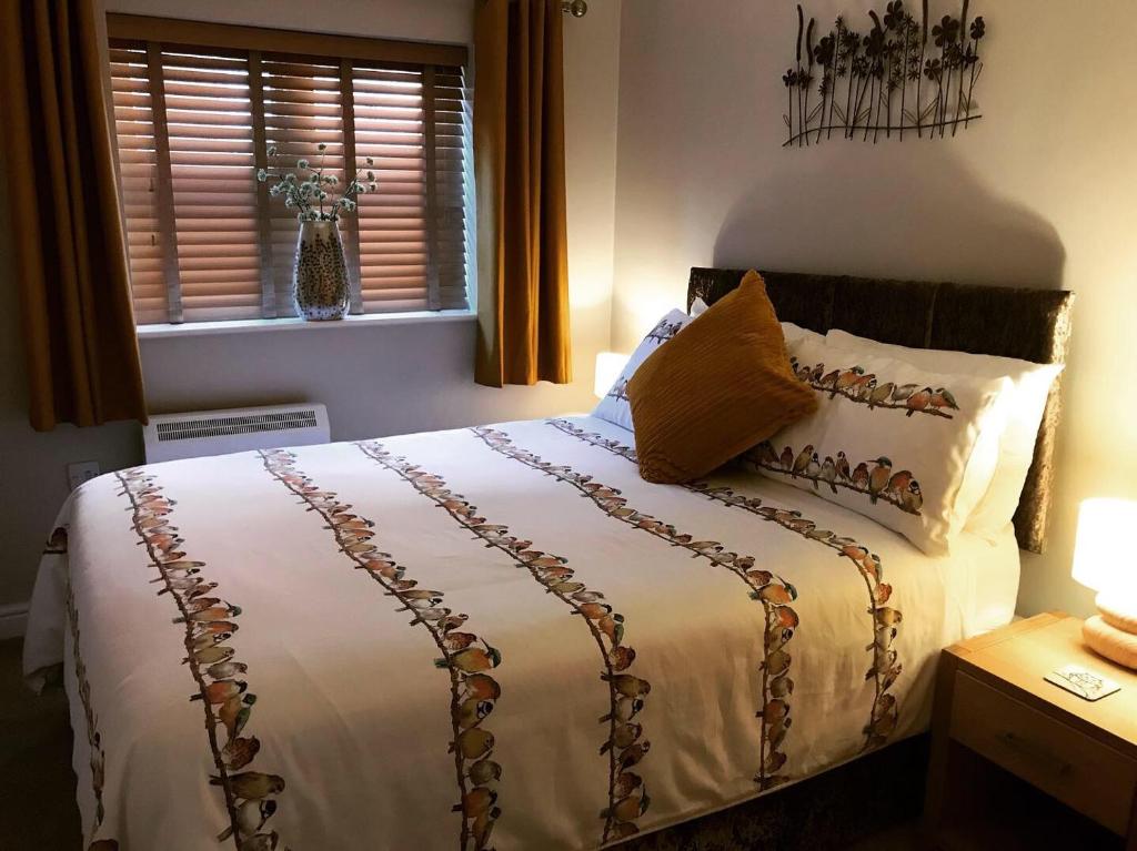 Schlafzimmer mit einem Bett mit weißer Bettwäsche und einem Fenster in der Unterkunft Clarabel's Guest House- The Nook in Wombourn