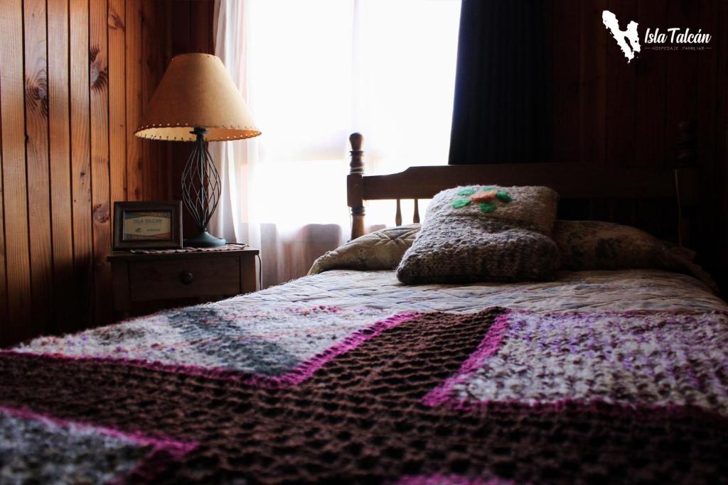 1 dormitorio con 1 cama con manta de ganchillo en Hospedaje Isla Talcan, en Dalcahue