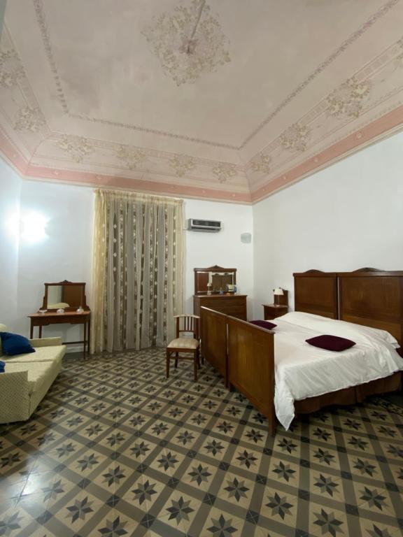 a hotel room with a bed, chair, and nightstand at Crispi accomodation in Catania