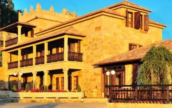 a large brick building with a porch and a balcony at O Paxareco De Ay in Meis