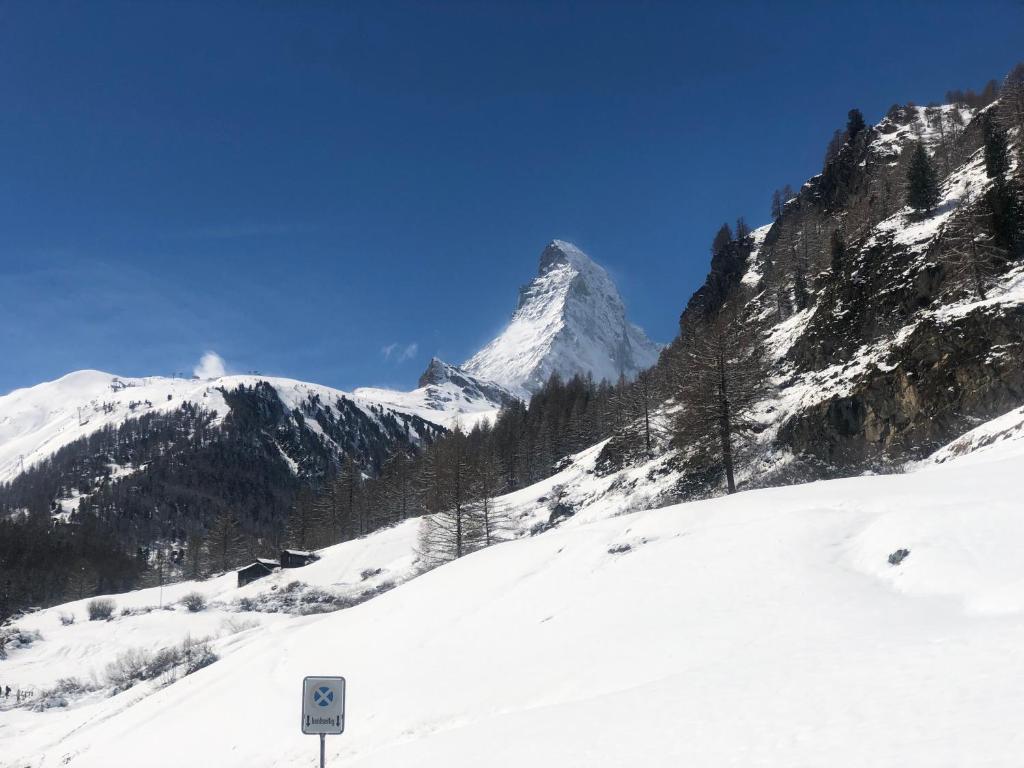 a snow covered mountain with a sign in front of it at Chalet Memory in Zermatt
