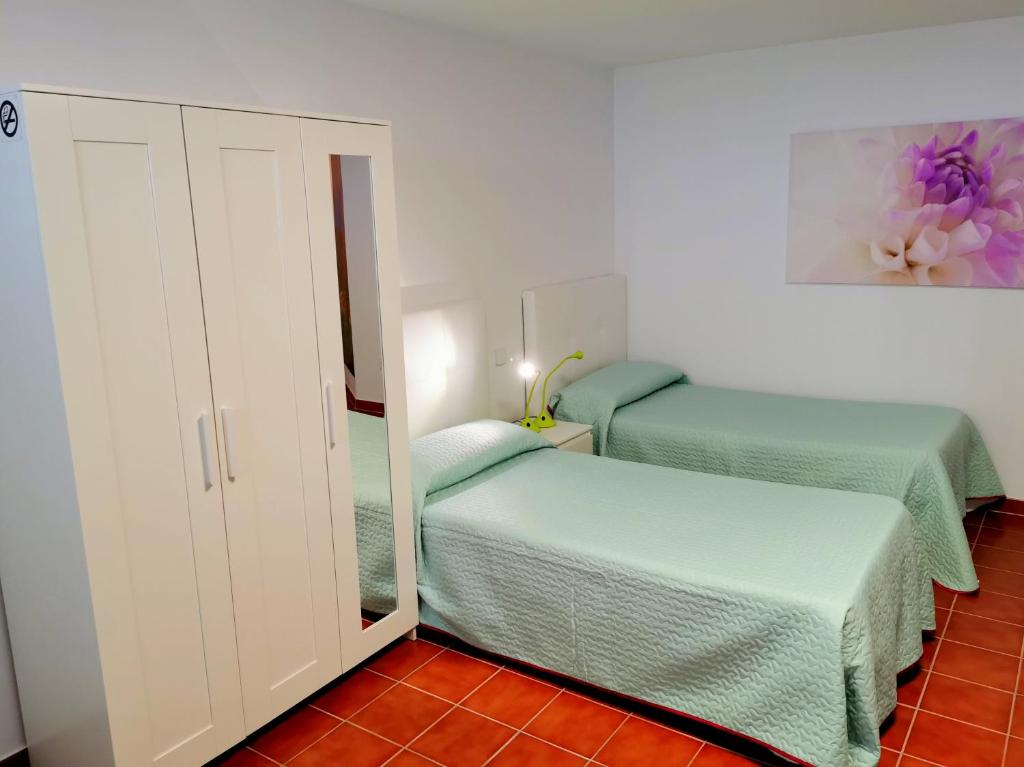 a small bedroom with two beds and a mirror at Casa del Sur, en el Sur de Tenerife in Granadilla de Abona