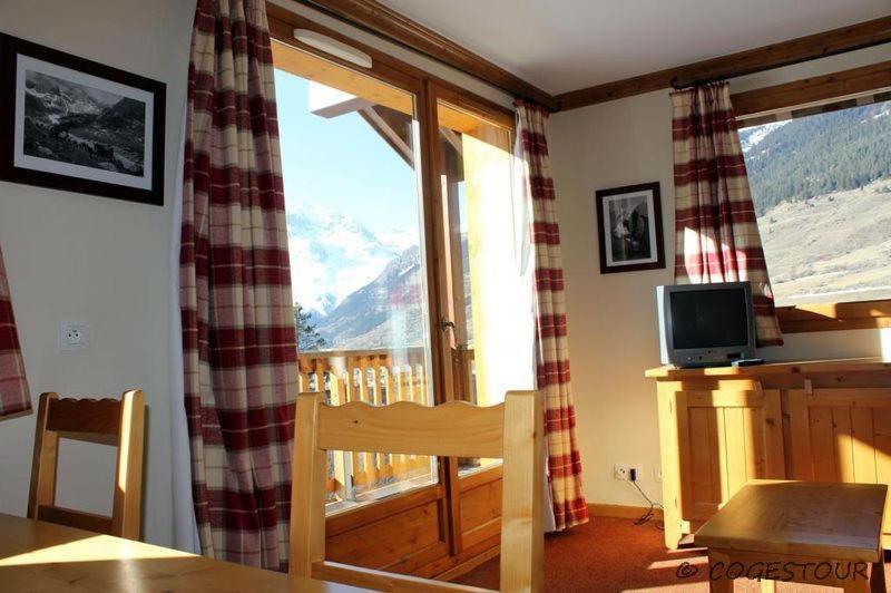 a living room with a large window with a mountain view at Les Alpages de Val Cenis 2p 4p in Lanslebourg-Mont-Cenis
