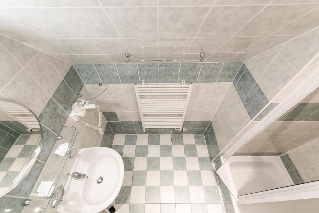 a bathroom with a sink and a toilet and a tub at Hotel Perla Jizery in Josefuv dul